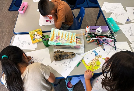 3rd graders with dinosaur crafts at MacArthur Park Elementary