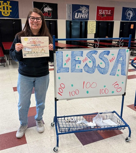 Lessa Acosta with her 100th reading club milestone certificate and 100+ name badge