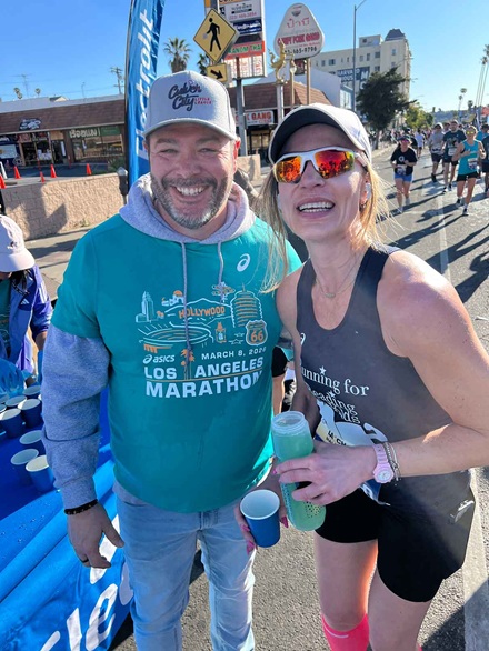 Reading to Kids volunteer at the Mile 9 water station with runner