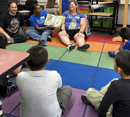 Volunteers and kids enjoying a book at the reading clubs