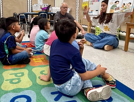 Volunteers and kids enjoying a book at the reading clubs