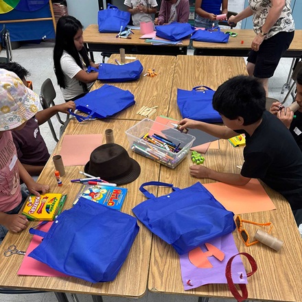 3rd graders with their blue Back to School supplies bags