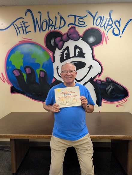 Food and bagel runner Jami Olson with his 160th reading clubs Milestone Certificate at Magnolia Elementary