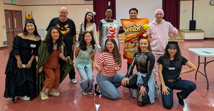 Charles White Elem. volunteers wearing Halloween costumes