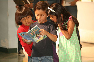 Three kids with a prize book