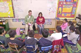 Reaching out. Nick Johnson and Anna Maglunog read books to fourth graders at Magnolia Elementary School Saturday on College Spirit Day.